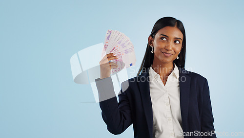 Image of Happy business woman, thinking and money fan in financial freedom against a blue studio background. Female person or employee in thought or wonder with cash, savings or investment on mockup space