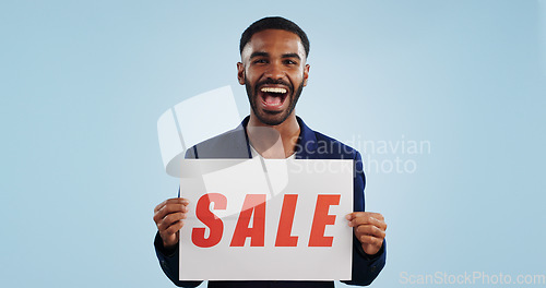 Image of Excited man, portrait and sale sign for advertising, deal or discount against a blue studio background. Happy male person showing billboard or poster for marketing, promotion or special on mockup