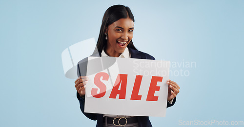 Image of Happy woman, portrait and sale sign for discount, advertising or deal against a blue studio background. Excited female person with billboard or poster for marketing, promo or special on mockup space