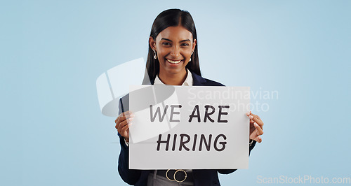 Image of Business woman, portrait and hiring sign for advertising opportunity or deal against a blue studio background. Female person smile with billboard or poster in job recruiting or career on mockup space