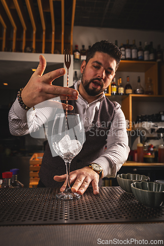 Image of Bartender stirring ice cubes