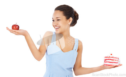 Image of Woman, apple and cake in studio portrait for healthy food choice, balance and diet decision. Happy, young person or model with red fruit versus cream dessert for detox or vegan on a white background