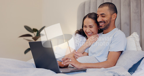 Image of Laptop, happy and young couple in bed watching movie, film or show together at home. Smile, technology and man and woman relaxing in bedroom streaming a video on computer for bonding at modern house.