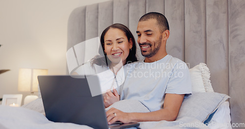 Image of Laptop, smile and young couple in bed watching movie, film or show together at home. Happy, technology and man and woman relaxing in bedroom streaming a video on computer for bonding at modern house.