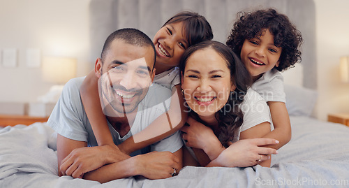 Image of Portrait, happy and kids with parents in bed relaxing and bonding together at family home. Smile, fun and young mother and father laying and resting with children in bedroom of modern house.