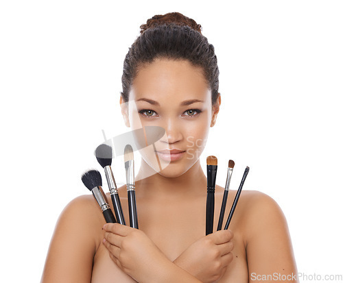 Image of Woman, portrait and makeup brushes in studio for beauty, foundation and cosmetics for coverage. Face of a young model or artist with skincare, application tools and product on a white background