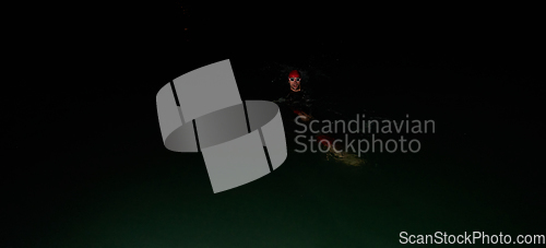 Image of Authentic triathlete swimmer having a break during hard training on night