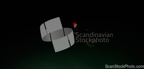 Image of Authentic triathlete swimmer having a break during hard training on night