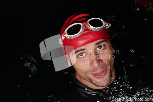 Image of Authentic triathlete swimmer having a break during hard training on night