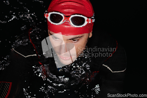 Image of Authentic triathlete swimmer having a break during hard training on night