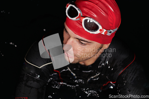 Image of Authentic triathlete swimmer having a break during hard training on night