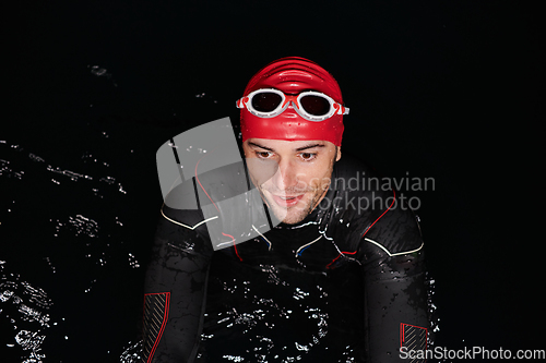Image of Authentic triathlete swimmer having a break during hard training on night