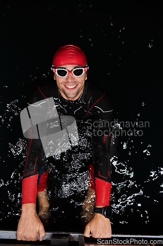 Image of A determined professional triathlete undergoes rigorous night time training in cold waters, showcasing dedication and resilience in preparation for an upcoming triathlon swim competition