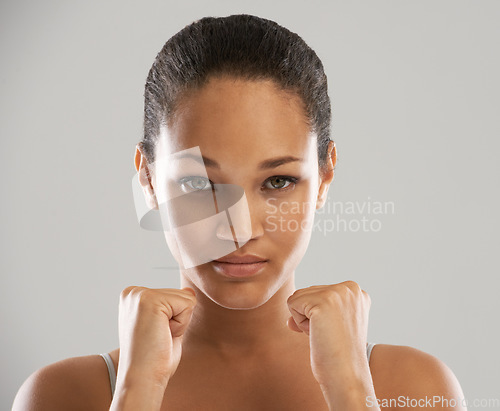 Image of Woman, portrait and fists for fight, self defense or fitness against a gray studio background. Face of female person or fighter with hands in martial arts for strength, power or protection on mockup