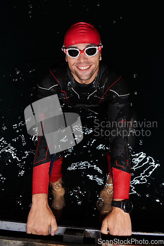 Image of A determined professional triathlete undergoes rigorous night time training in cold waters, showcasing dedication and resilience in preparation for an upcoming triathlon swim competition