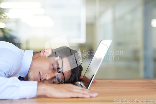 Image of Business man, laptop and sleeping at desk, exhausted and burnout in office or dreaming in workplace. Male professional, nap and overtime or overworked, stress and fatigue or tired and deadline