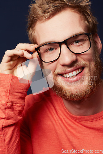 Image of Man, face and glasses for fashion or eye care with black frame and smile on dark background. Model is happy with prescription lens, designer eyewear and casual clothes in studio with style and vision