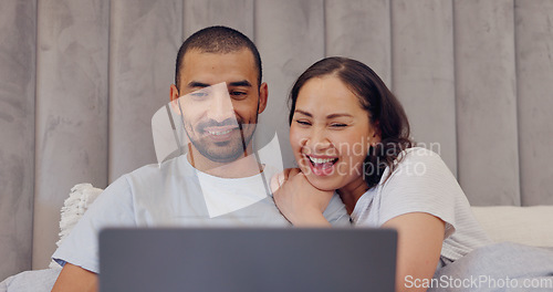 Image of Laptop, happy and young couple in bed watching movie, film or show together at home. Smile, technology and man and woman relaxing in bedroom streaming a video on computer for bonding at modern house.