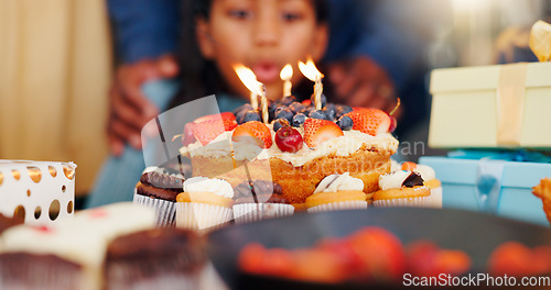 Image of Happy birthday, cake and candle light in celebration with family for party, holiday or special day at home. Closeup of little girl blowing flame for wish in growth, love or care and bonding at house