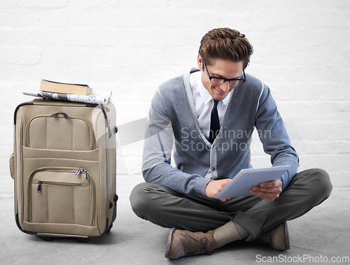 Image of Business man, reading or luggage with tablet, floor and smile with app, flight or travel by wall background. Entrepreneur, person or employee with digital touchscreen, bag and happy for immigration