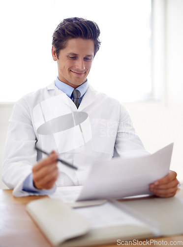 Image of Happy, document and portrait of man doctor in the office for consultation in a medical hospital. Smile, reading and professional young male healthcare worker with paperwork for research in a clinic.