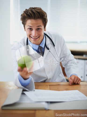 Image of Happy, apple and portrait of man doctor with stethoscope for positive, good and confident attitude. Smile, pride and young male healthcare worker with fruit in medical office of hospital or clinic.