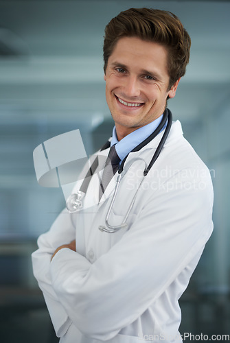 Image of Smile, crossed arms and portrait of man doctor with stethoscope for positive, good and confident attitude. Happy, pride and young male healthcare worker in medical office of hospital or clinic.