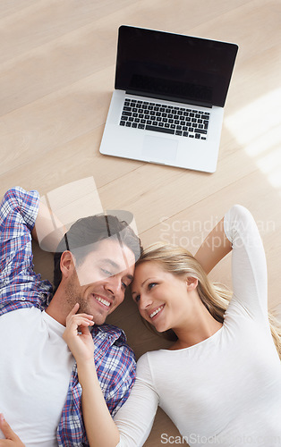 Image of Happy couple, touch and living room floor with laptop, marriage and relax for love, home and tech. Wife, husband and smile for commitment, bonding together and care for relationship, man or woman