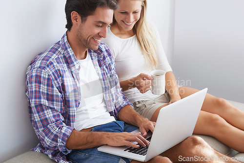 Image of Couple, happy and laptop on sofa in home for movie, social media or web streaming with bonding and love. Technology, man or woman with computer pc or coffee for internet scroll and tv show with care