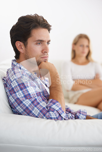 Image of Man, angry and living room couch with disagreement, upset and thinking with anger, fight or mad. Divorce, betrayal and relationship with cheating, stress and argument for marriage, home and woman