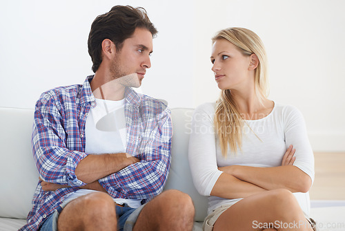 Image of Couple, angry and living room couch with disagreement, upset and staring with anger, fight or mad. Divorce, betrayal and relationship with cheating, stress and argument for marriage, home or toxic