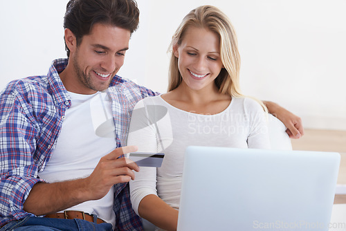 Image of Happy couple, laptop and credit card for ecommerce, payment or banking together in relax at home. Man and woman smile with debit on computer for online shopping, transaction or fintech at house