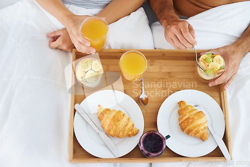 Image of Couple, food and breakfast in bed for morning, wakeup or meat and snack together in relax at home. Top view of man and woman hands eating healthy for diet, nutrition or vitamin c juice in bedroom