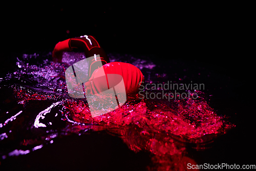 Image of Authentic triathlete swimmer having a break during hard training on night neon gel light