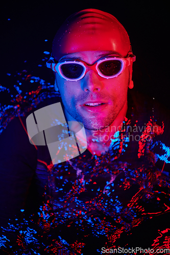 Image of authentic triathlete swimmer having a break during hard training on night neon gel light