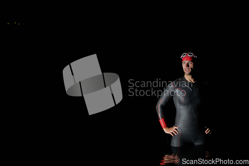 Image of Authentic triathlete swimmer having a break during hard training on night