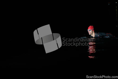 Image of Authentic triathlete swimmer having a break during hard training on night