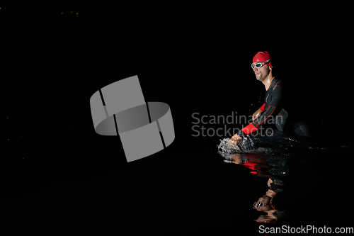 Image of Authentic triathlete swimmer having a break during hard training on night