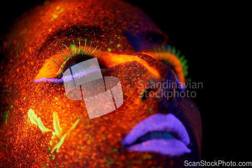 Image of Art, woman with neon paint on face and beauty, closeup with bright lipstick and creative skincare on dark background. Orange glow, disco aesthetic and model in studio for creativity with makeup