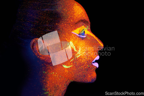 Image of Art, woman and profile with neon paint on face and beauty, bright lipstick and creative skincare on dark background. Orange glow, disco aesthetic and model in studio for creativity with makeup