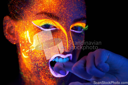 Image of Art, woman with neon face paint and beauty, portrait with bright lipstick and creative skincare on dark background. Orange glow, disco aesthetic and model in studio for creativity with makeup