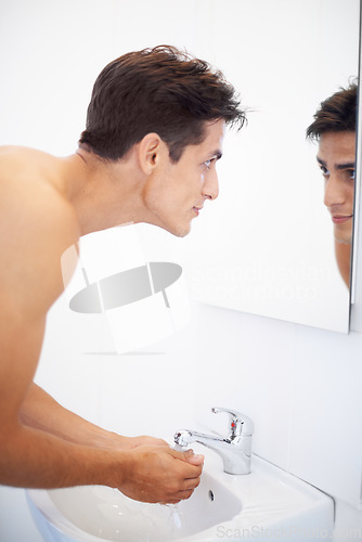 Image of Man, washing hands and water for hygiene in mirror, clean and protection from bacteria. Male person, bathroom and wellness in morning routine, reflection and grooming or self care and basin at home