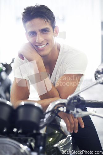 Image of Happy man, portrait and motorcycle in garage for cool transportation or small vehicle at home. Face of young handsome male person or biker smile and leaning on cool automobile or mechanical motorbike