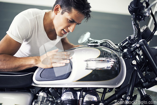 Image of Handsome man, motorcycle and looking at bike in garage for transportation or vehicle inspection. Young male person or biker admiring motor, engine or cool mechanical power on motorbike in parking lot