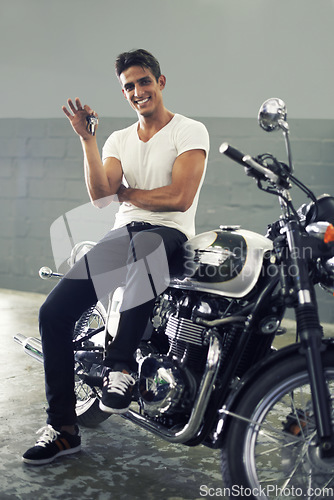 Image of Happy man, portrait and keys sitting on motorcycle keys for transportation or vehicle in garage. Young male person or biker smile for cool automobile, ownership or mechanical motorbike in parking lot