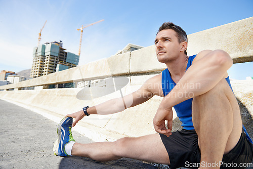 Image of Man, stretching legs and runner in city, warm up for cardio workout and fitness outdoor. Athlete, sports and running in New York with health, wellness and ready for race or marathon on urban bridge