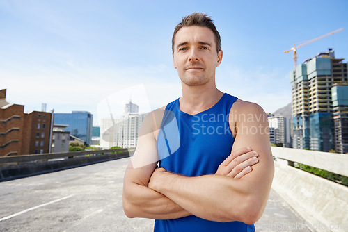 Image of Man, arms crossed in city and fitness outdoor with workout, training and athlete in portrait for sports. Confidence, face and exercise on urban bridge, health and wellness with sportswear in Chicago