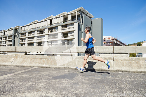 Image of Man is running on bridge, exercise and cardio outdoor for health and training for marathon. Fitness in city, runner with speed and energy, sports and athlete on urban street for race and endurance