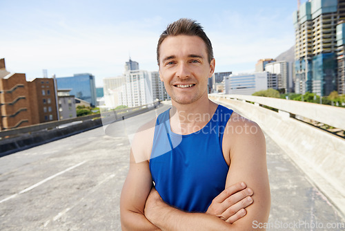 Image of Happy man, arms crossed in city and fitness outdoor for workout, training and athlete smile in portrait for sports. Confidence, face and exercise on urban bridge, health and wellness in Chicago