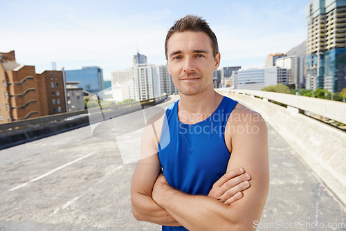 Image of Man, arms crossed in city and exercise outdoor with workout, training and athlete in portrait for sports. Confidence, face and fitness on urban bridge, health and wellness with sportswear in Chicago